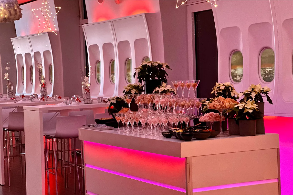 Weiße Bar mit Champagnergläsern und Weihnachtssternen in einer Flugzeug-Location