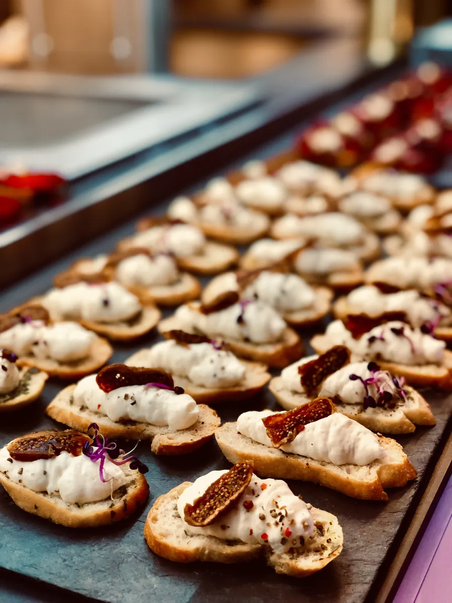 Crostini mit Creme und Topping auf Schieferplatte