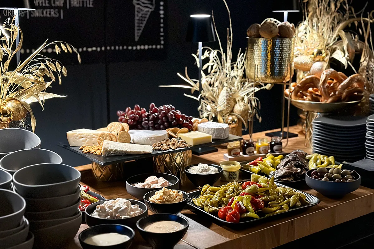 Weihnachtsbuffet mit Käse, Brezeln und goldener Dekoration